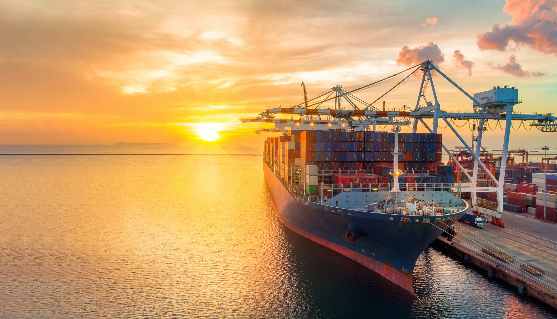 Container vessel loading at an international port at sunset for a cross trade shipment